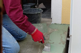 Verstreichen der Dichtungsmasse auf dem grundierten Balkon des Weiheraums